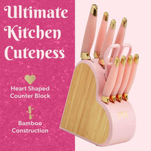 Heart-shaped knife block with pink handles and gold details, on a wooden base.