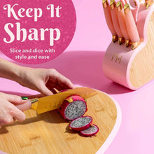Pink handled knife slicing on a wooden board with a heart-shaped knife block