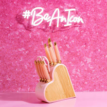 White and gold heart-shaped knife block holding multiple pink-handled knives