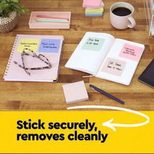 Pastel sticky notes and notepad pages on a desk with a pen