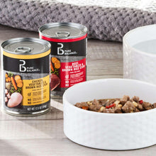 Wet dog stew cans with open bowl of wet food on wooden table