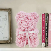 Light pink artificial rose teddy bear with white ribbon bow and dense rose petals
