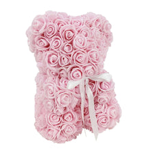 Light pink artificial rose teddy bear with white ribbon bow, front view