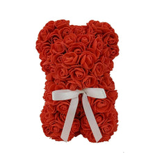 Red artificial rose bear with white ribbon bow, centered on white background