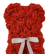 Red artificial rose bear with white ribbon bow, close-up front view