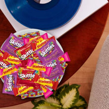 Assorted Skittles and Starburst candy wrappers on a plate