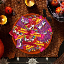 Assorted Skittles and Starburst candy wrappers in a bowl