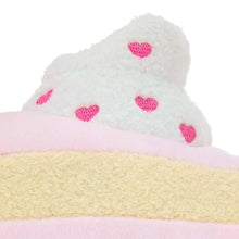White plush cake top with pink heart pattern and a tan layer beneath