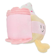 Pink and white plush strawberry cake with smiling face, tan base, and curled legs