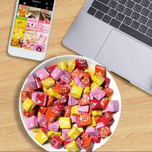 Bowl of assorted Starburst chewy candy pieces with phone on the side