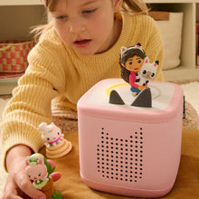 Pink Toniebox displaying an audio toy figurine of a girl holding a white cat