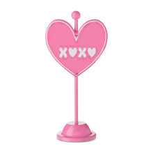 Pink metal heart tabletop sign with XOXO lettering on two-sided design