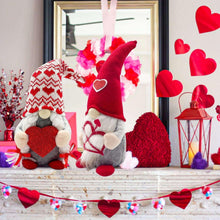 Two plush Valentine gnomes with knit hats and red heart fronts on a ledge