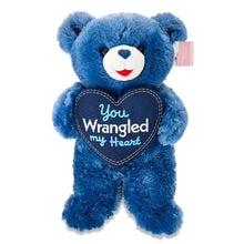Blue teddy bear plush with navy heart patch “You Wrangled my Heart”, small tag on back