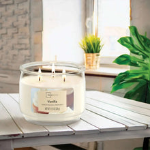 Vanilla three-wick glass jar candle with cream wax and visible product label