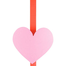 Pink heart ornament with red ribbon top