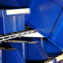 Rolling storage rack with wheels, blue bins and angled top compartment divider